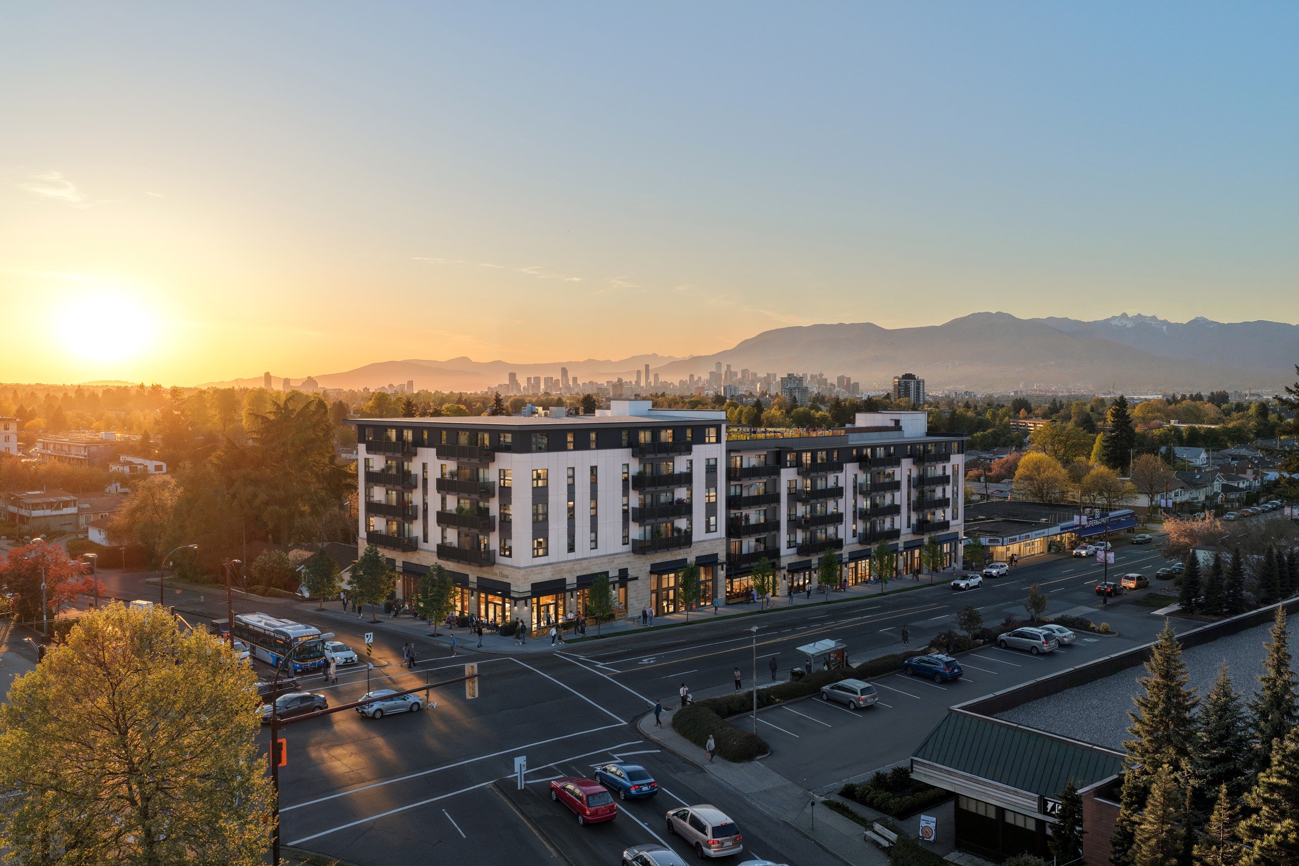 A sunset view of a city street with cars and buildings.